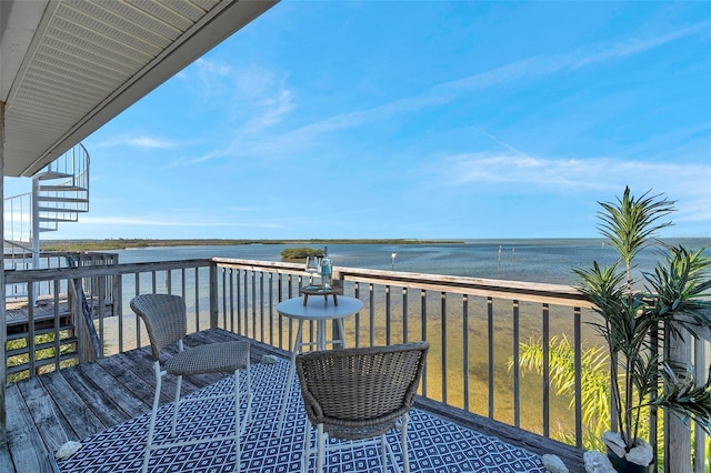 balcony with stairs and a water view