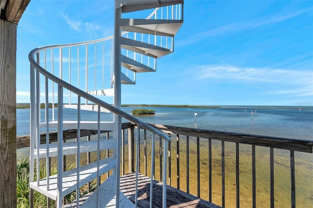 balcony with a water view and stairway
