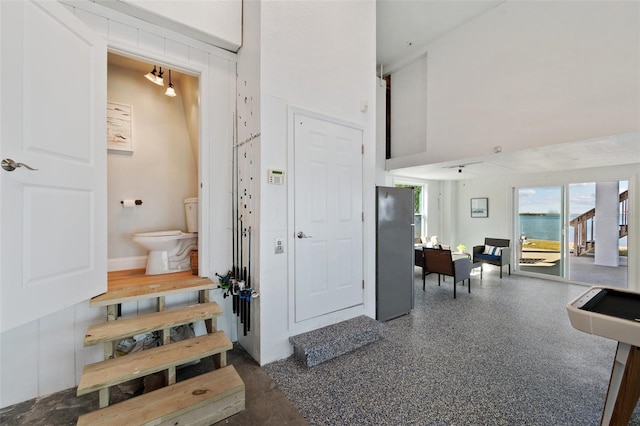 interior space featuring speckled floor and a towering ceiling