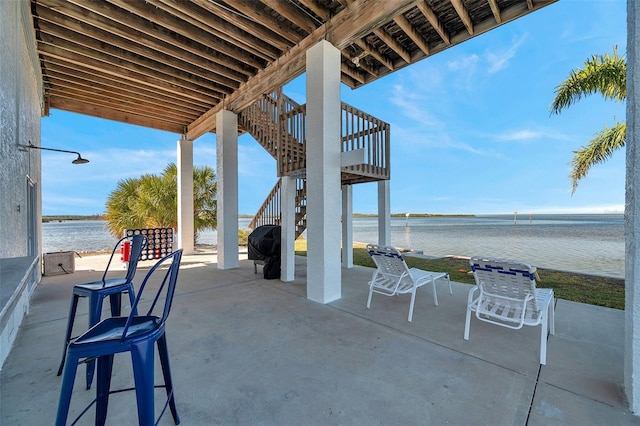 view of patio / terrace with a water view and stairway