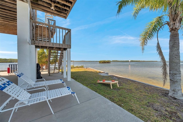 view of patio with a water view and stairway