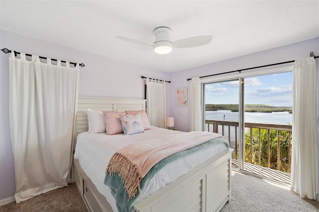 bedroom featuring access to outside, carpet flooring, a water view, and ceiling fan
