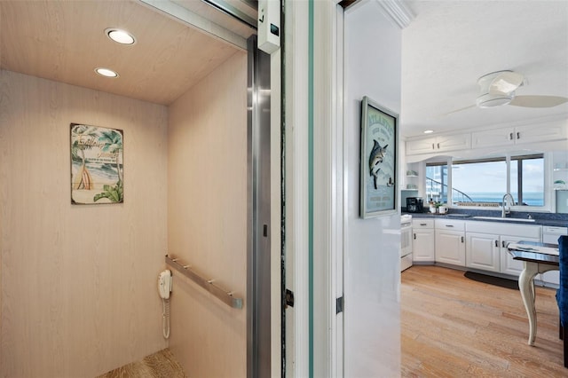 bathroom featuring recessed lighting, wood finished floors, elevator, and vanity