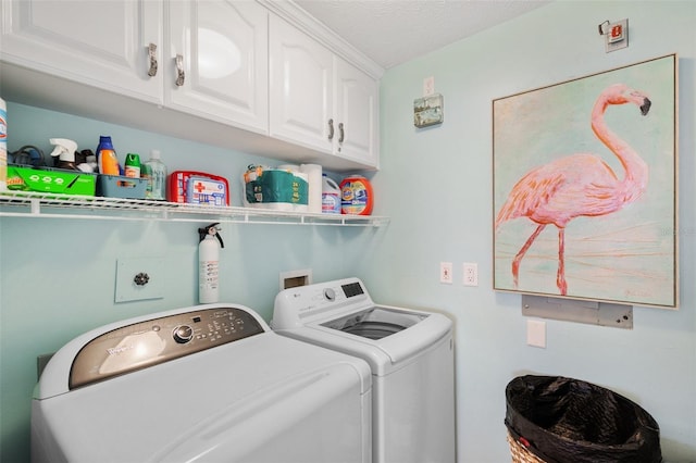 washroom with cabinet space and washer and dryer
