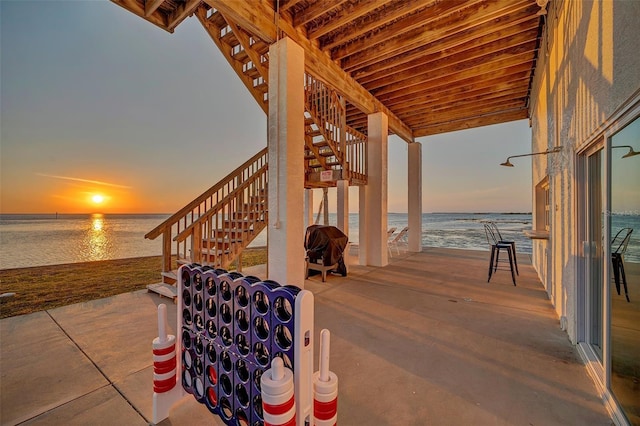 view of patio / terrace featuring a water view and stairway