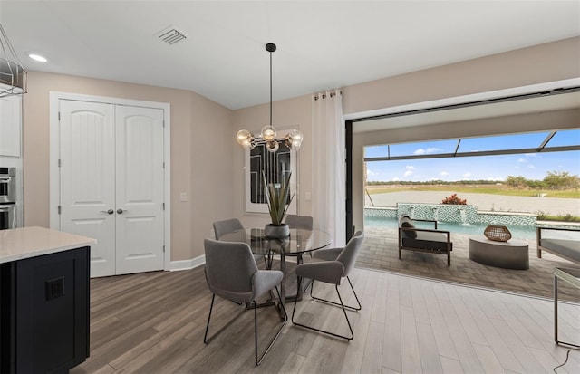 dining room with a chandelier, recessed lighting, baseboards, wood finished floors, and visible vents