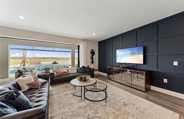 living room featuring baseboards, wood finished floors, and a wealth of natural light