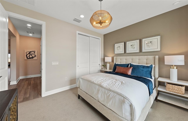 carpeted bedroom featuring visible vents, baseboards, and an inviting chandelier