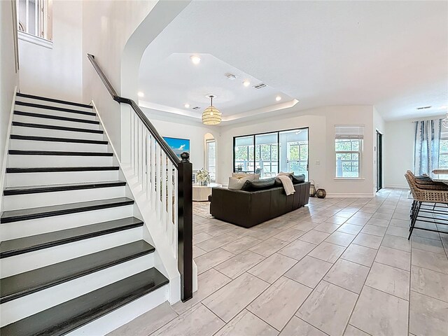 18203 Pine Hammock Blvd, Lutz, FL 33548 - living room with stairway, recessed lighting, arched walkways, baseboards, and a tray ceiling