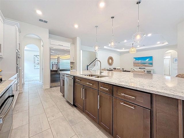 18203 Pine Hammock Blvd, Lutz, FL 33548 - kitchen with arched walkways, appliances with stainless steel finishes, a sink, dark brown cabinets, and white cabinetry