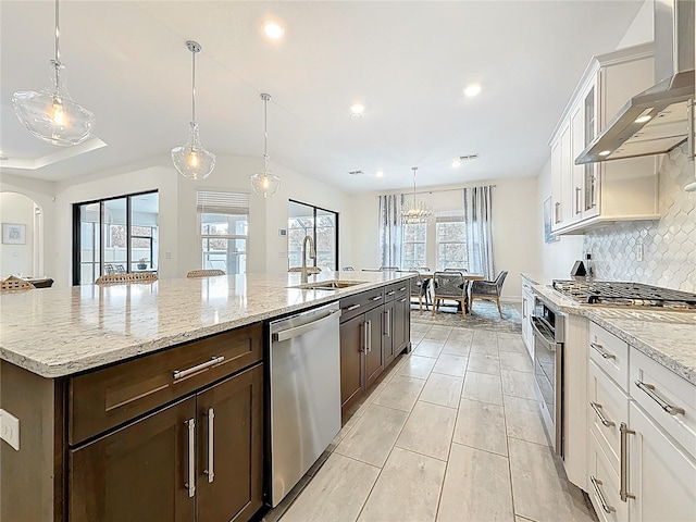 18203 Pine Hammock Blvd, Lutz, FL 33548 - kitchen featuring stainless steel appliances, wall chimney range hood, a sink, dark brown cabinets, and tasteful backsplash