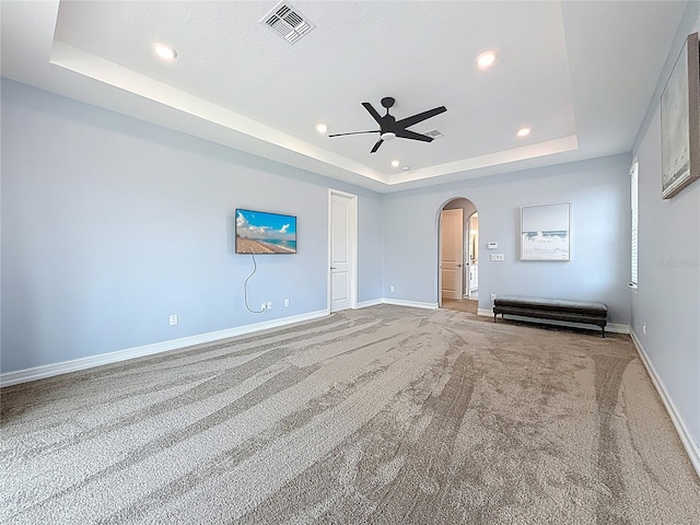 18203 Pine Hammock Blvd, Lutz, FL 33548 - carpeted empty room featuring a tray ceiling, arched walkways, ceiling fan, baseboards, and recessed lighting