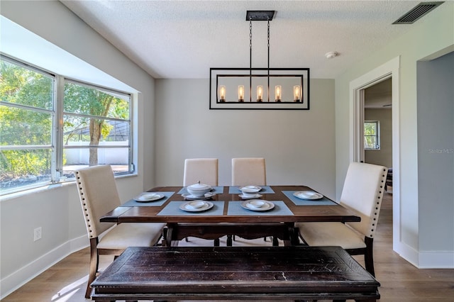 dining room featuring baseboards, visible vents, and wood finished floors
