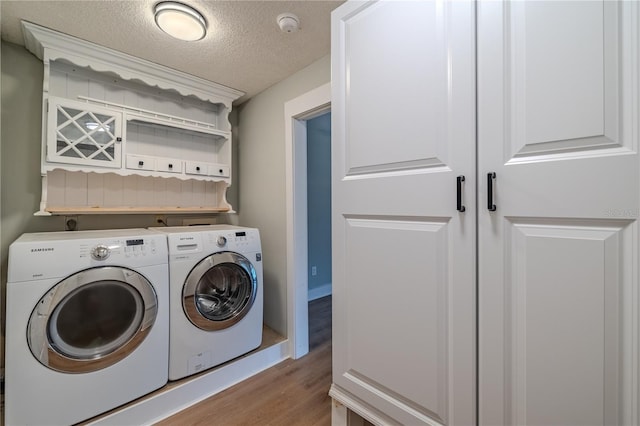 clothes washing area featuring a textured ceiling, light wood finished floors, and independent washer and dryer