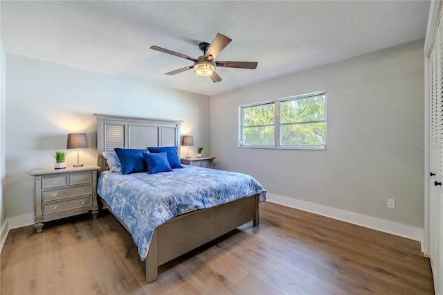 bedroom featuring baseboards, ceiling fan, and wood finished floors