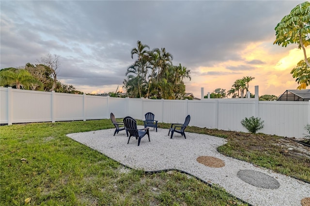yard at dusk featuring a fenced backyard and a patio area