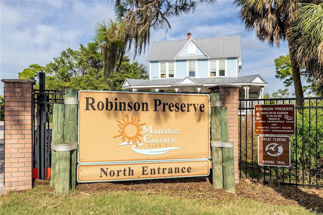community / neighborhood sign featuring fence