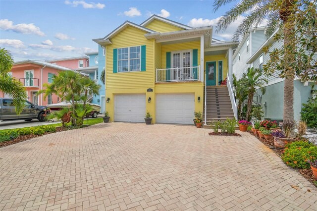 1326 Apollo Beach Blvd S, Apollo Beach, FL 33572 - coastal home with an attached garage, stucco siding, decorative driveway, and stairway