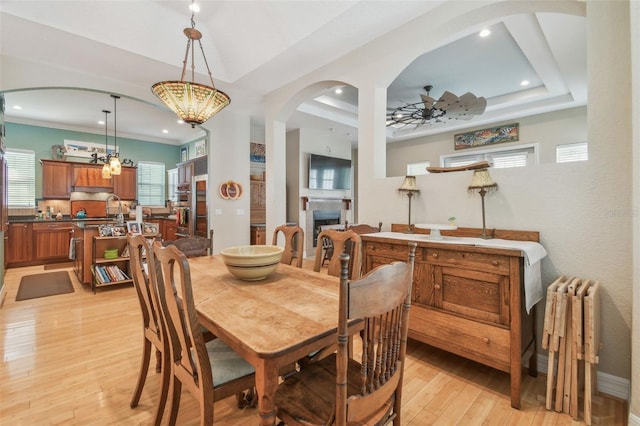 1326 Apollo Beach Blvd S, Apollo Beach, FL 33572 - dining space featuring arched walkways, radiator heating unit, a ceiling fan, light wood-type flooring, and a tray ceiling