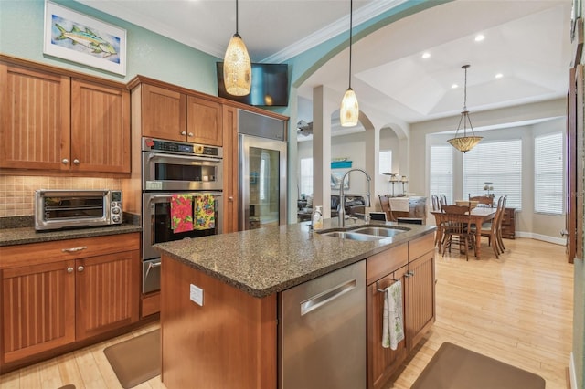 1326 Apollo Beach Blvd S, Apollo Beach, FL 33572 - kitchen featuring arched walkways, brown cabinets, a sink, a toaster, and stainless steel appliances