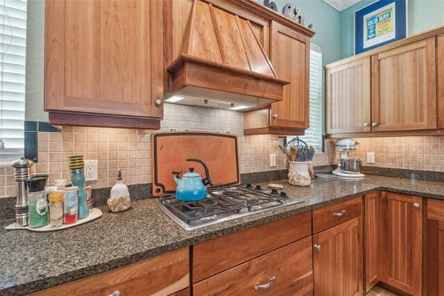 1326 Apollo Beach Blvd S, Apollo Beach, FL 33572 - kitchen with custom range hood, decorative backsplash, dark stone countertops, and stainless steel gas stovetop
