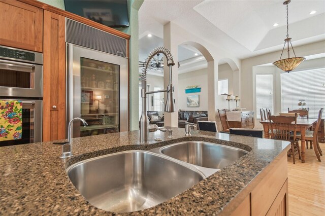 1326 Apollo Beach Blvd S, Apollo Beach, FL 33572 - kitchen with light wood-type flooring, a sink, double oven, dark stone counters, and a tray ceiling