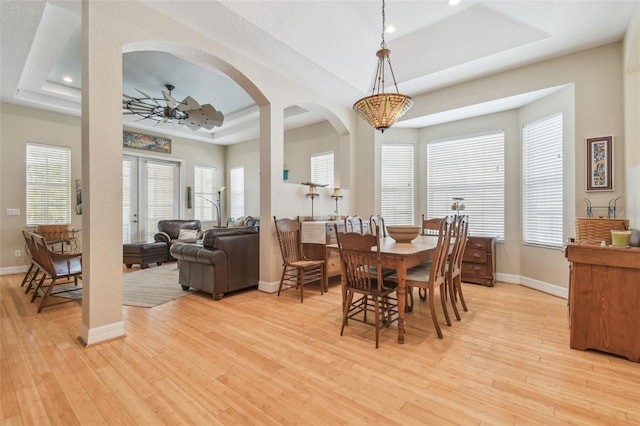 1326 Apollo Beach Blvd S, Apollo Beach, FL 33572 - dining space featuring a raised ceiling, baseboards, light wood-type flooring, and arched walkways