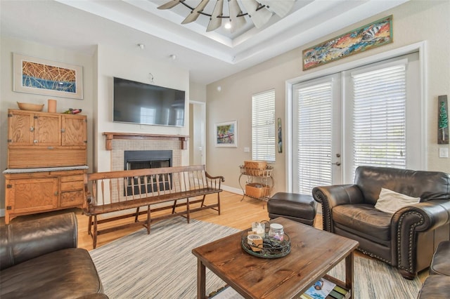 1326 Apollo Beach Blvd S, Apollo Beach, FL 33572 - living area with a raised ceiling, baseboards, a brick fireplace, and light wood-style flooring