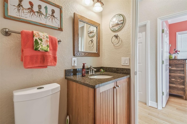 1326 Apollo Beach Blvd S, Apollo Beach, FL 33572 - half bath featuring vanity, a textured wall, toilet, and wood finished floors
