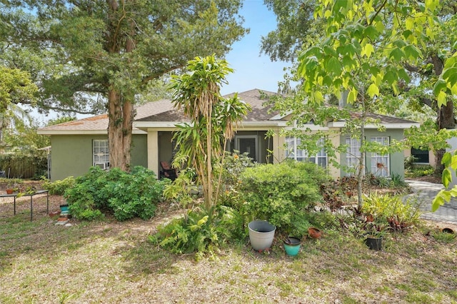 single story home featuring fence, stucco siding, and roof with shingles