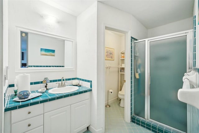 full bathroom featuring vanity, tile patterned flooring, a stall shower, and toilet