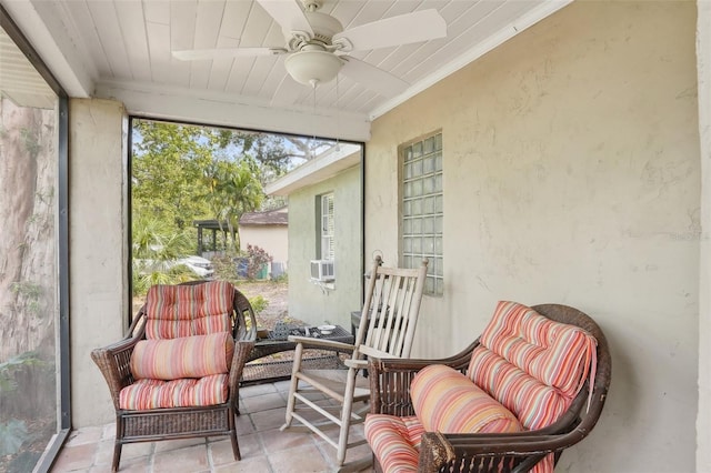 sunroom with crown molding, ceiling fan, and a textured wall