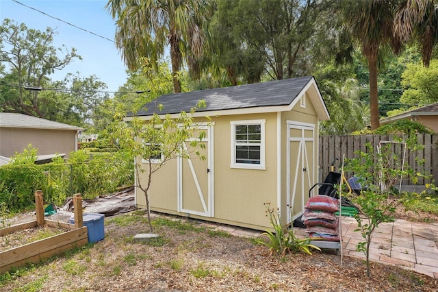 view of shed featuring fence and a vegetable garden
