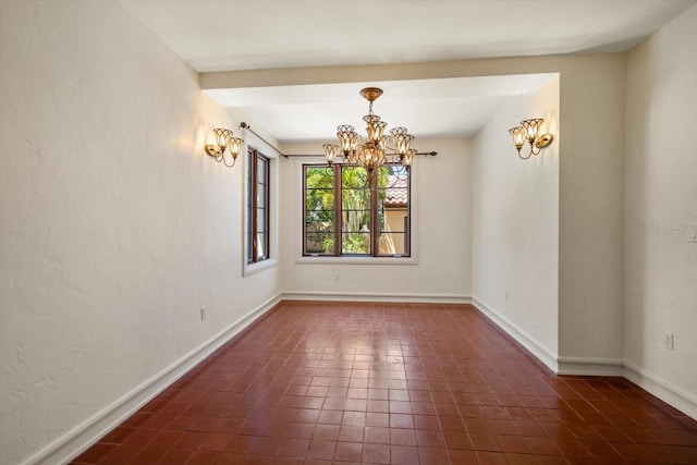 unfurnished dining area featuring baseboards and an inviting chandelier