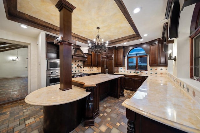 kitchen featuring custom range hood, a sink, stainless steel oven, and dark brown cabinetry
