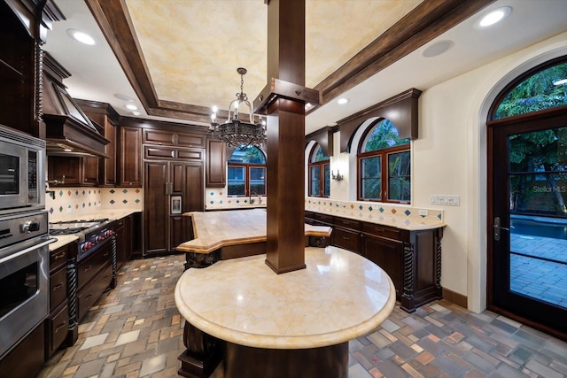 foyer with stone finish floor, baseboards, recessed lighting, and a notable chandelier
