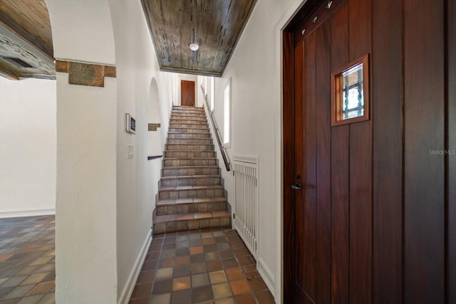 interior space with baseboards and wood ceiling