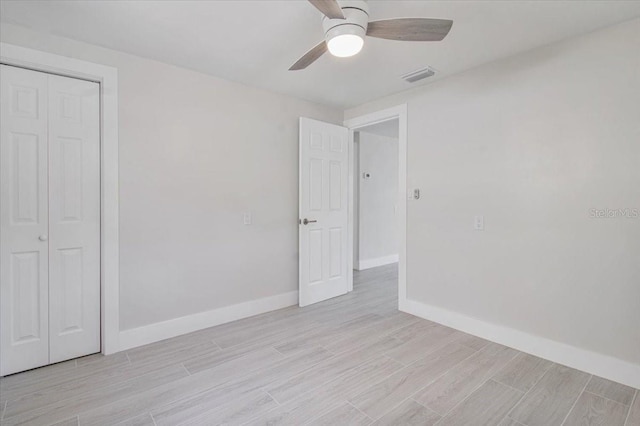 2728 58th St S, Gulfport, FL 33707 - unfurnished bedroom featuring light wood-type flooring, baseboards, a closet, and ceiling fan