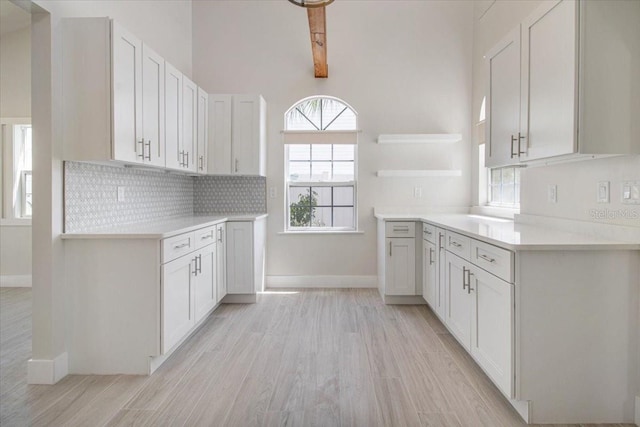 2728 58th St S, Gulfport, FL 33707 - kitchen featuring open shelves, light wood finished floors, light countertops, tasteful backsplash, and baseboards