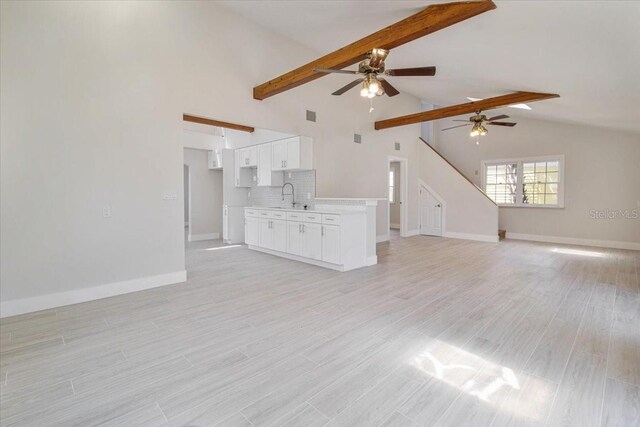 2728 58th St S, Gulfport, FL 33707 - unfurnished living room featuring ceiling fan, a sink, baseboards, and light wood-style flooring