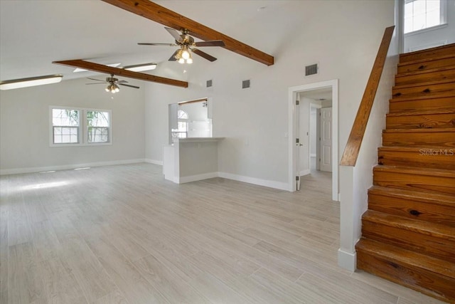 2728 58th St S, Gulfport, FL 33707 - unfurnished living room with stairway, ceiling fan, beam ceiling, baseboards, and high vaulted ceiling