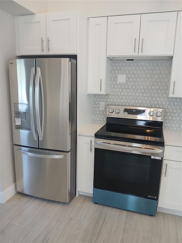2728 58th St S, Gulfport, FL 33707 - kitchen with appliances with stainless steel finishes, white cabinets, light countertops, and decorative backsplash