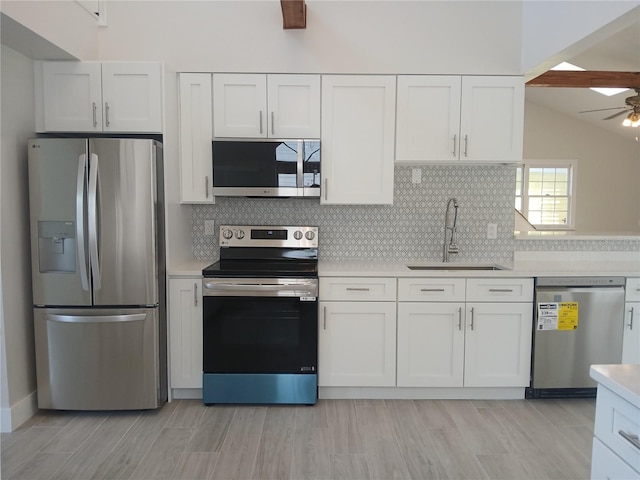 2728 58th St S, Gulfport, FL 33707 - kitchen with stainless steel appliances, a sink, light countertops, tasteful backsplash, and lofted ceiling