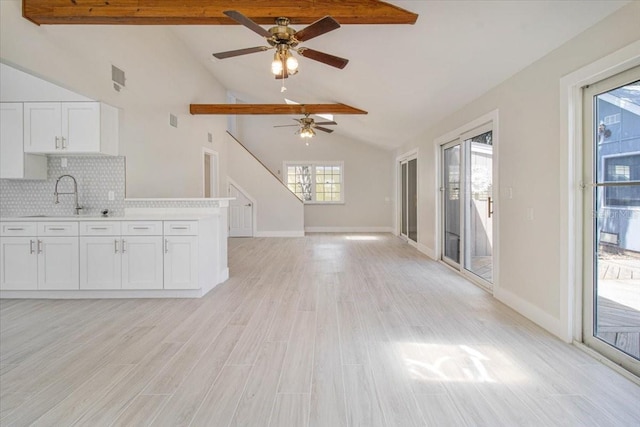 2728 58th St S, Gulfport, FL 33707 - kitchen with a sink, a ceiling fan, beamed ceiling, white cabinetry, and light countertops