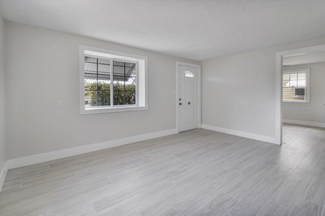 2728 58th St S, Gulfport, FL 33707 - foyer with light wood finished floors, a textured ceiling, and baseboards