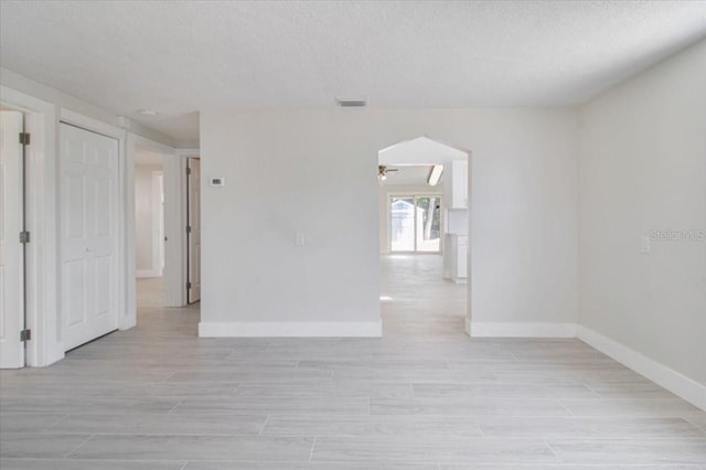 2728 58th St S, Gulfport, FL 33707 - spare room featuring baseboards, ceiling fan, light wood finished floors, and a textured ceiling
