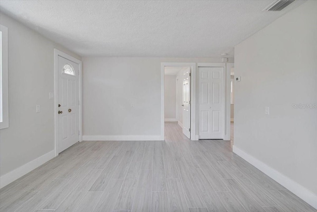 2728 58th St S, Gulfport, FL 33707 - spare room featuring a textured ceiling, light wood-style flooring, and baseboards