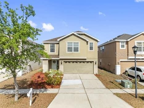 traditional-style home featuring concrete driveway and a garage