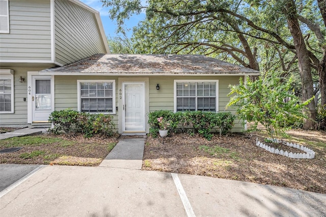 entrance to property featuring a shingled roof