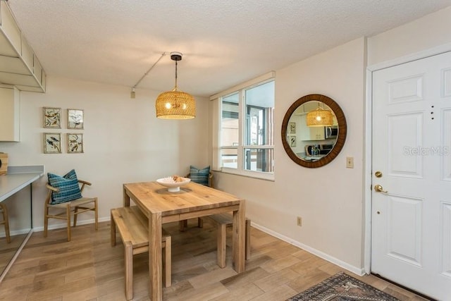 17900 Gulf Blvd Unit 1B, Redington Shores, FL 33708 - dining area featuring light wood-style floors, a textured ceiling, and baseboards